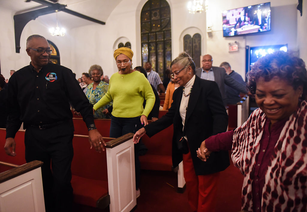Attendees reach for each others' hands